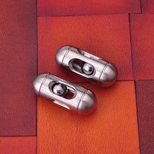 Load image into Gallery viewer, Pair of stainless steel capsule fidget toys on desk surface