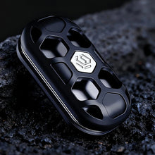 Charger l'image dans la galerie, Black openwork metal fidget slider on a dark textured surface
